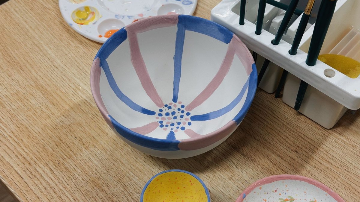 Handbemalte Keramikschale mit abwechselnd blauen und altrosa Streifen und kleinen Punkten in der Mitte