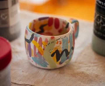 Keramikbecher mit bunten, abstrakten Pinselstrichen und Wellenlinien