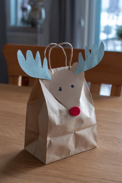 23. Papiertüten-Elchgeschenk für Basteln mit Kindern Weihnachten Papier mit Klammerohren und Nasenstempel