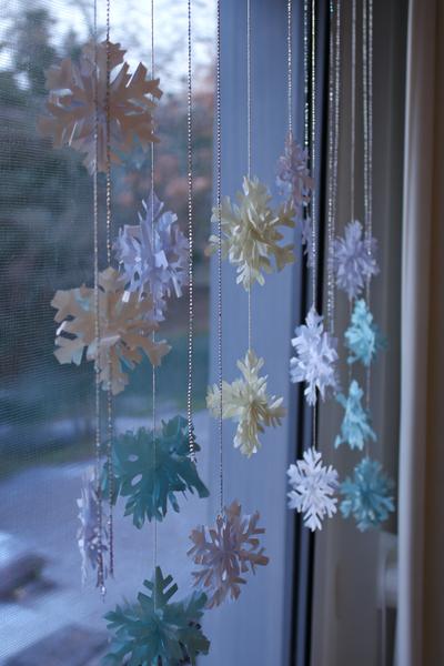 6. Schneeflocken-Mobile beim Basteln mit Kindern Winter mit Papierstanzern und silbernen Fäden