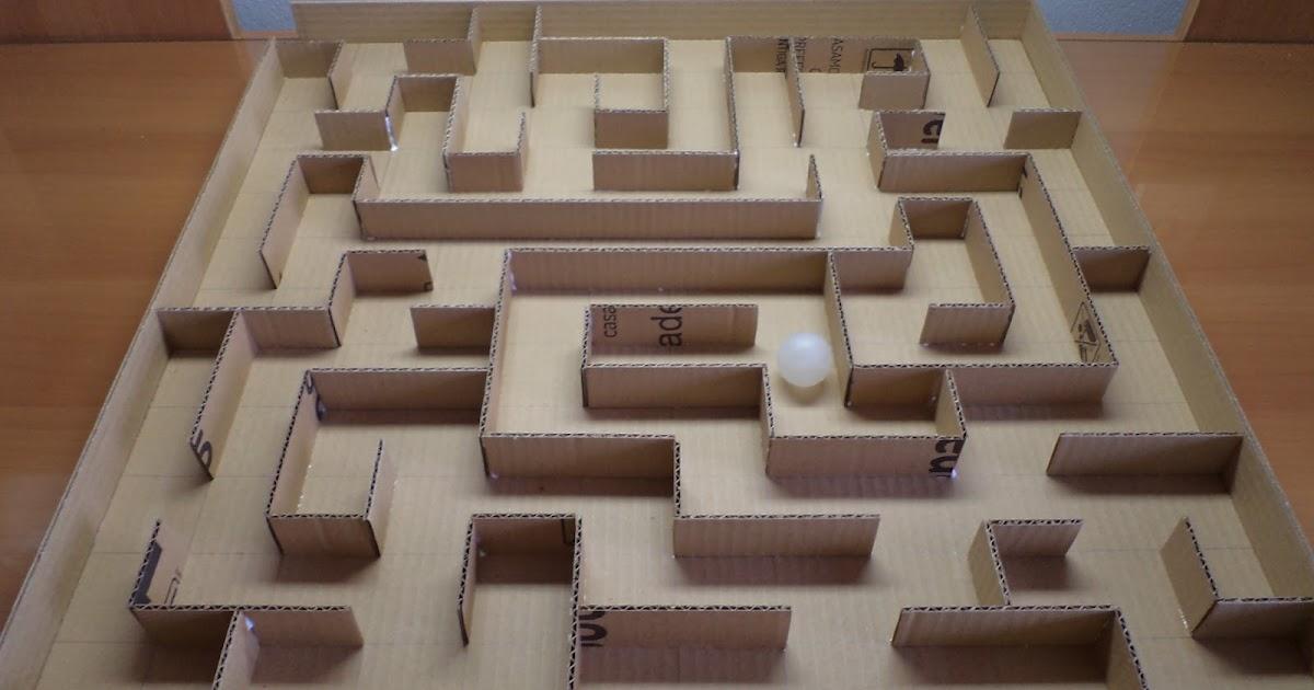 Großes Labyrinth aus Pappwänden auf einer Grundplatte mit einem weißen Ball in der Mitte